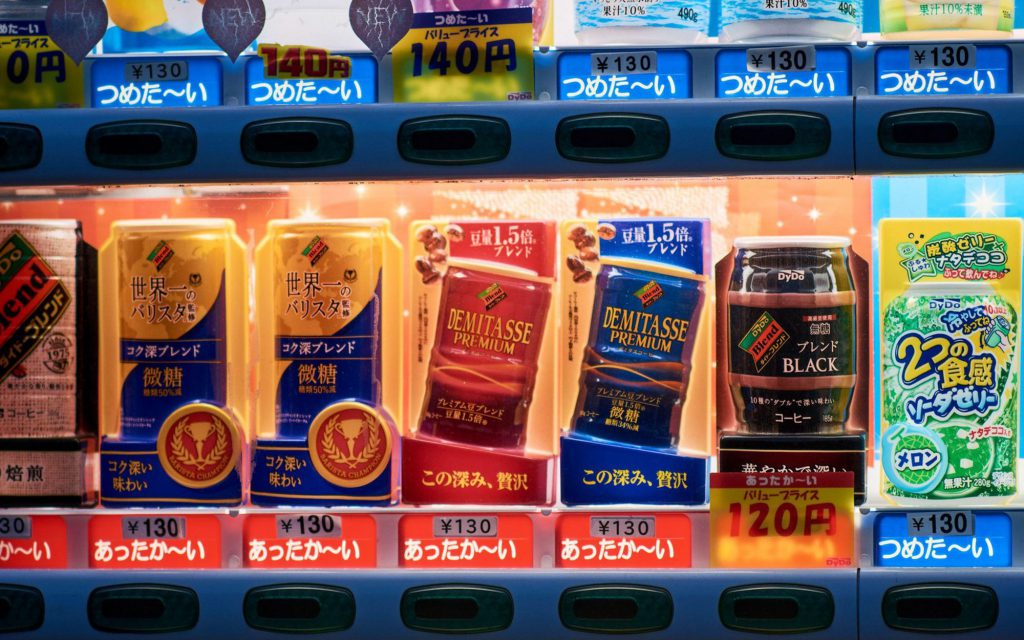 Various types of canned coffee in a Japanese vending machine.